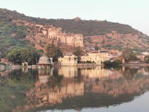 a town on a hill next to a body of water at Haveli Elephant Stable in Būndi