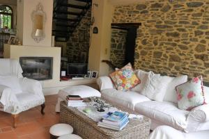 a living room with white furniture and a stone wall at Wonderful 4 Bedroom Villa & separate guest house Villa Thalia in Zagora