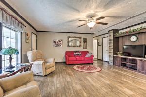 a living room with a red couch and a tv at Lovely Sadieville Retreat with Deck and Grill! in Corinth