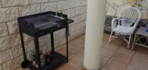 a barbecue grill sitting on a floor next to a chair at Villa Azul in Callao Salvaje