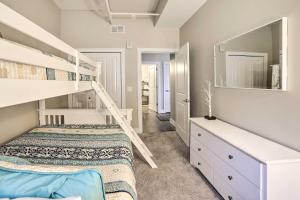 a bedroom with two bunk beds and a mirror at Luxe Manistee Condo with Balcony and River Views! in Manistee