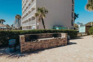 a brick retaining wall in front of a building at Sandcastle Oceanfront Resort South Beach in Myrtle Beach