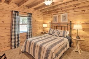 1 dormitorio con 1 cama en una cabaña de madera en Serenity Woods Cabin with Hot Tub and Fire Pit, en Mountain Home