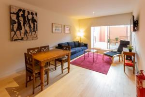 a living room with a table and a blue couch at Garça Real Flats in Porto