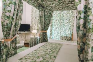 a bedroom with a bed and curtains and a desk at Eveline Portosole Hotel in Sanremo +76 photos