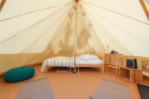 a room with a tent with a bed and mats at Valea Doftanei Glamping in Teşila