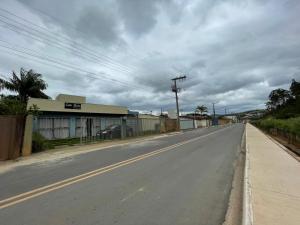 an empty street in a town with a cloudy sky at Suítes em Capitolio in Capitólio