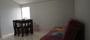 een woonkamer met een stoel en een tafel bij Apartamento con linda terraza en San Antonio in Cali