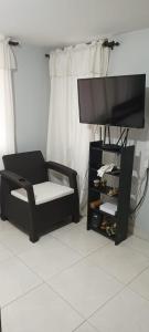een woonkamer met een stoel en een flatscreen-tv bij Apartamento con linda terraza en San Antonio in Cali