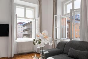 ein Wohnzimmer mit einem Sofa und 2 Fenstern in der Unterkunft Spacious 2BR Apt. Rennweg - Perfect for Longstays. in Wien