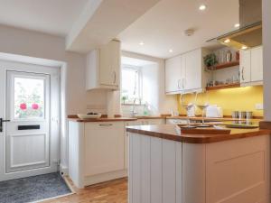 a kitchen with white cabinets and a counter top at Rose Cottage in Clitheroe