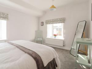 a bedroom with a bed and a mirror and a window at Rose Cottage in Clitheroe