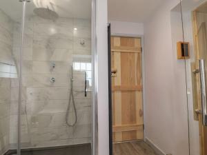 a bathroom with a shower with a glass door at Rose Cottage in Clitheroe