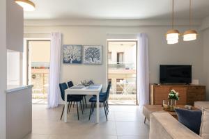 een keuken en een woonkamer met een tafel en stoelen bij Harbour Hill Suites in Rethimnon
