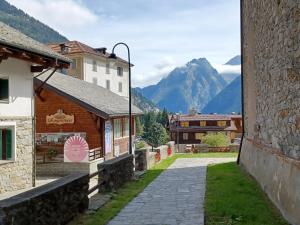 a street in a village with mountains in the background at Residenza Le Fontane in Ceppo Morelli