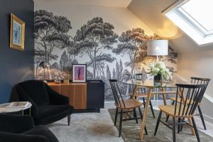 une salle à manger ornée d'une fresque murale représentant des arbres dans l'établissement Le 10Honfleur, à Honfleur