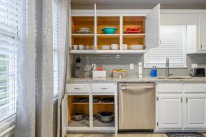a kitchen with white cabinets and a sink at Embrace The Outdoors In This Modern Rydal Setting in White +20 photos