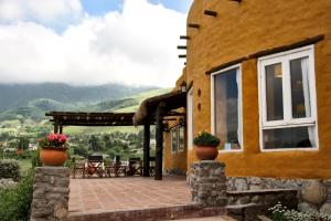 ein Haus mit einer Terrasse mit Bergblick in der Unterkunft Posada La Guadalupe in Tafí del Valle