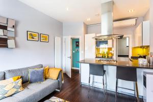 a living room with a couch and a kitchen at Exmouth Market Apartment in London