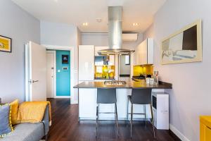 a kitchen with a kitchen island with chairs and a couch at Exmouth Market Apartment in London