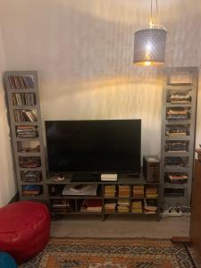 un centro de entretenimiento con TV de pantalla plana en la sala de estar en La petite maison, en Crépy-en-Valois