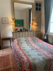 1 dormitorio con cama y espejo grande en La petite maison en Crépy-en-Valois
