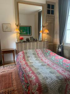Un dormitorio con una cama y un espejo grande. en La petite maison, en Crépy-en-Valois