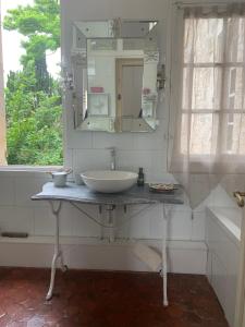 a bathroom with a sink and a mirror at La petite maison in Crépy-en-Valois