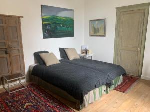 Un dormitorio con una cama grande en una habitación. en La petite maison, en Crépy-en-Valois