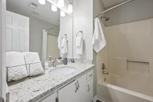 a white bathroom with a sink and a tub at Disconnect From The City In This Outdoorsy Getaway in White +51 photos