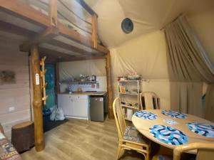a dining room with a table and a kitchen at Glamping Drzwi Do Lasu in Supraśl