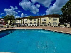 a large blue swimming pool in front of a building at Luxury • Modern • CLOSE2DISNEY • 3bed • 2bath in Kissimmee