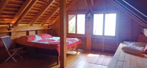 una camera con un letto in una cabina di legno di RAIATEA - The BEACH HOUSE - plage sur le lagon ! a Tevaitoa
