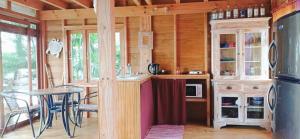 a kitchen with a counter and a table in a cabin at RAIATEA - The BEACH HOUSE - plage sur le lagon ! in Tevaitoa