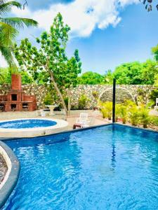 a swimming pool in a yard with two chairs at Villa Marcia in Boca Chica