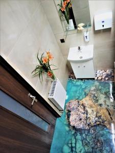 a bathroom with a floor that looks like a pool of water at Pensjonat Pocztówka in Zgierz