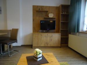 sala de estar con TV y mesa en Mutzkopf en Nauders