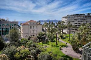 widok na park z palmami i budynek w obiekcie REF 1757 - Cannes Back Croisette - Sea view apartment for rent w Cannes