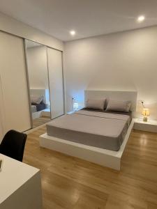 um quarto com uma cama grande e um espelho grande em Duarte Apartments - Lux em Mindelo