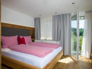 a bedroom with a bed with red and white pillows at Landgasthof Lusenblick in Grafenau