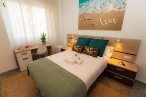 um quarto com uma cama com dois bichos de peluche em Hostal Ventura Premium em Alicante