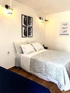 1 dormitorio con 1 cama grande con sábanas blancas en Chalé Recanto dos Anjos Arraial do Cabo, en Arraial do Cabo