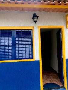 una casa con una pared azul y amarilla y una puerta en Chalé Recanto dos Anjos Arraial do Cabo, en Arraial do Cabo