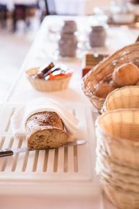 una hogaza de pan sobre una mesa con cestas de pan en Hostel Engelberg, en Engelberg