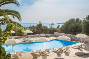 a swimming pool with chairs and umbrellas at Eagle's Nest in Lourdhata