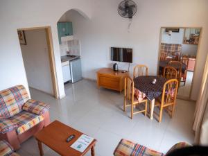 pequeña sala de estar con mesa y cocina en Cape Point Hotel en Bakau