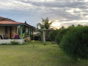 a house with a yard with a fence and trees at Casa Floramar in Parajuru