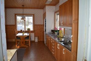 a kitchen with wooden cabinets and a table in it at Countryside Holiday home "Our Little Farm" in Hagfors