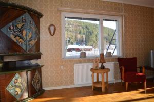 a room with a window and a chair and a table at Countryside Holiday home "Our Little Farm" in Hagfors