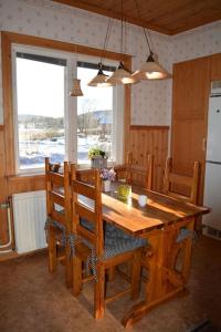 a wooden table and chairs in a kitchen with a table and a window at Countryside Holiday home "Our Little Farm" in Hagfors